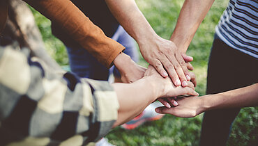 985577158 Stacking hands of young teen student, teamwork, togetherness and cooperation concept
